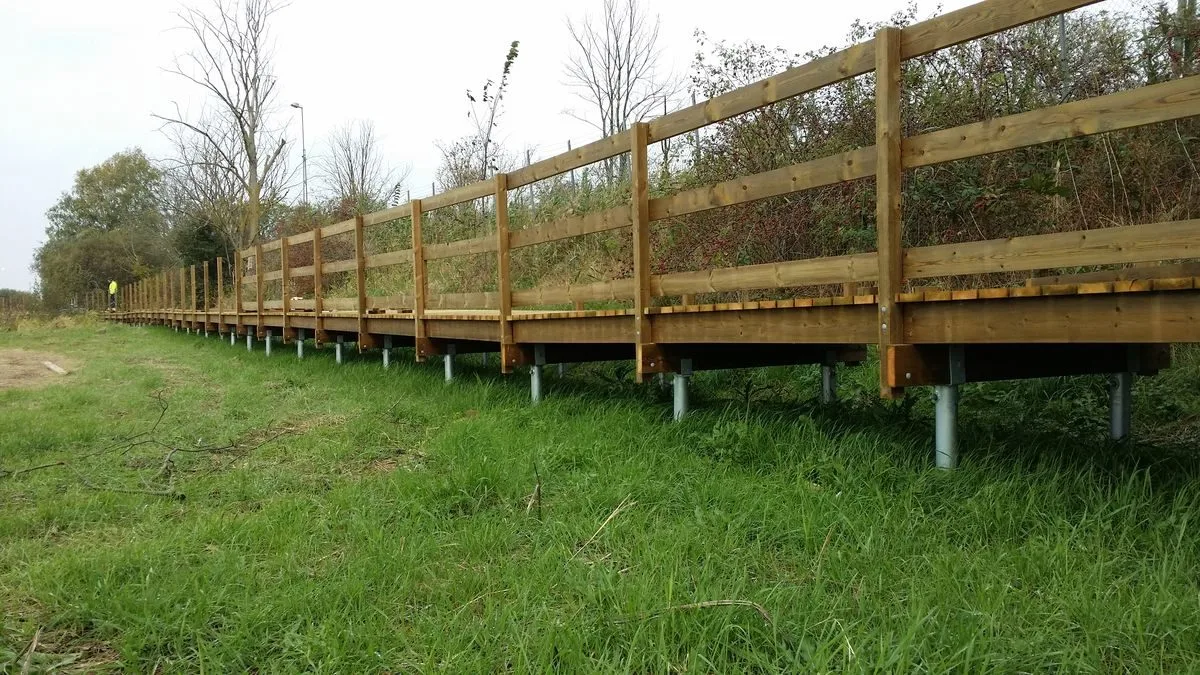 Pasarela de madera terminada sobre pilotes helicoidales